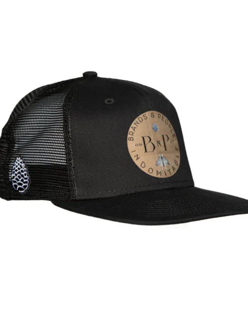 Side view of a black hat with Old Gold B&P logo on front and pinecone on the side